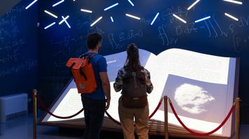 zwei Personen vor dem digitalen Buch im UniGraz@Museum bei der Langen Nacht der Forschung