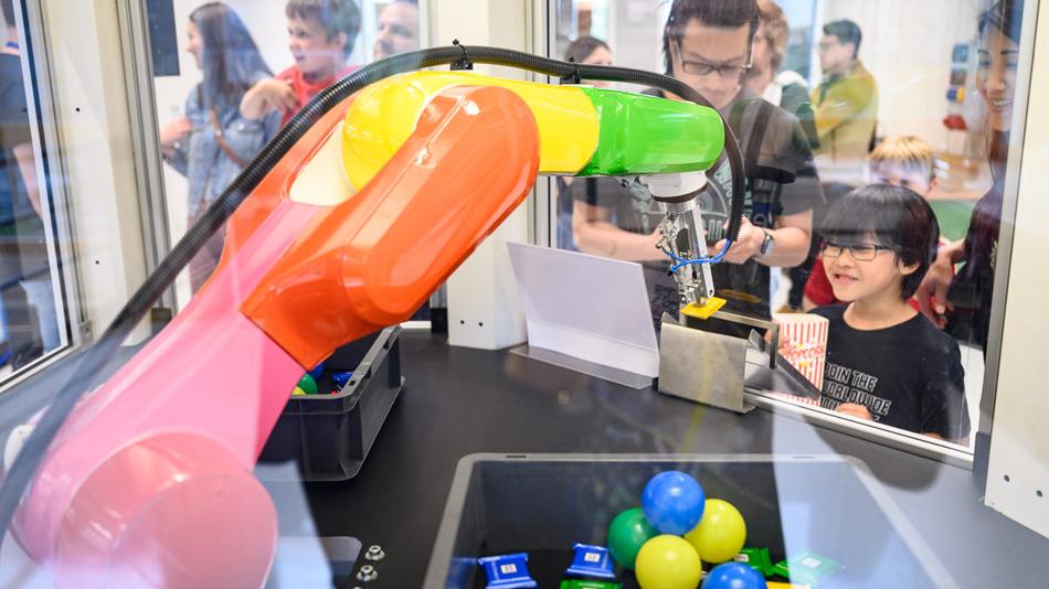 Junge beobachtet gespannt einen Roboter