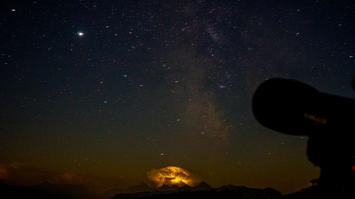 Gewitter mit klarem Sternenhimmel und Teleskop im Vordergrund