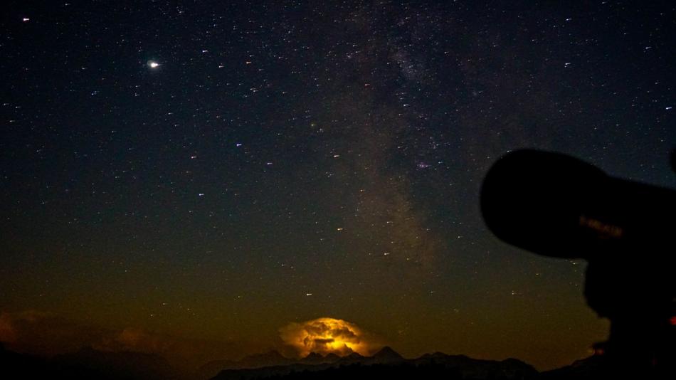 Gewitter mit klarem Sternenhimmel und Teleskop im Vordergrund
