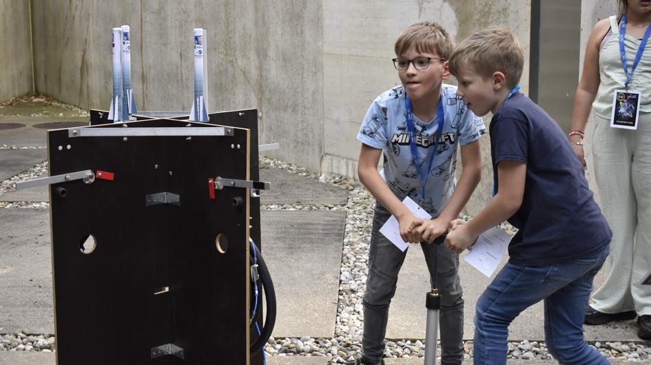 zwei Buben bei der Startrampe für die Papierraketen