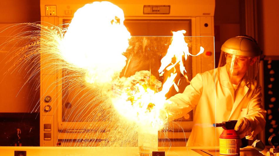 Experiment mit hohen Flammen und Mensch in Schutzkleidung