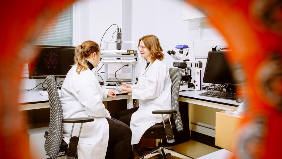 Zwei Forscherinnen diskutieren im Labor über Analyseergebnisse zur Kunststoffsortierung und zum mechanischen Recycling