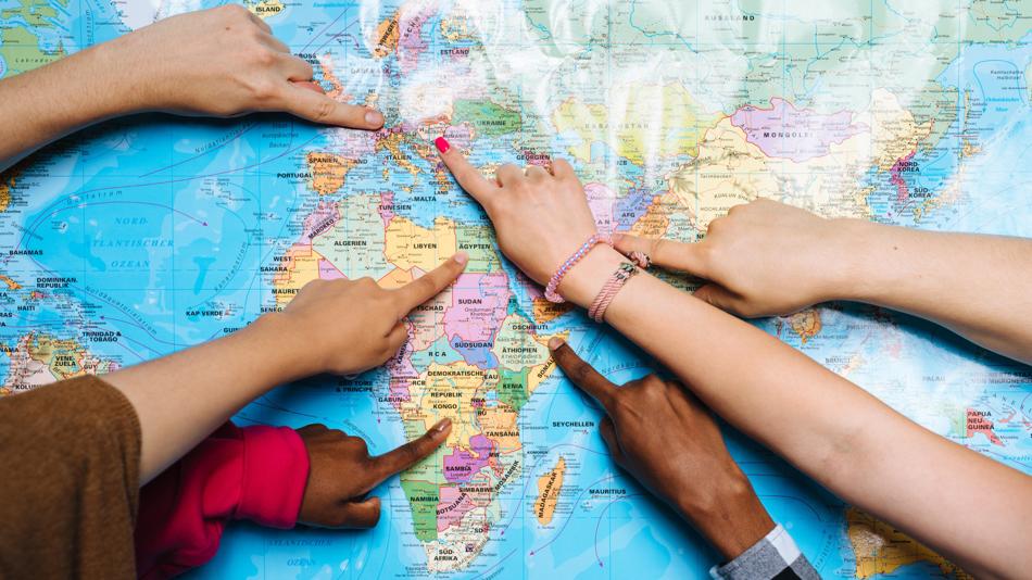 Finger zeigen auf verschieden Orte auf einer Landkarte.