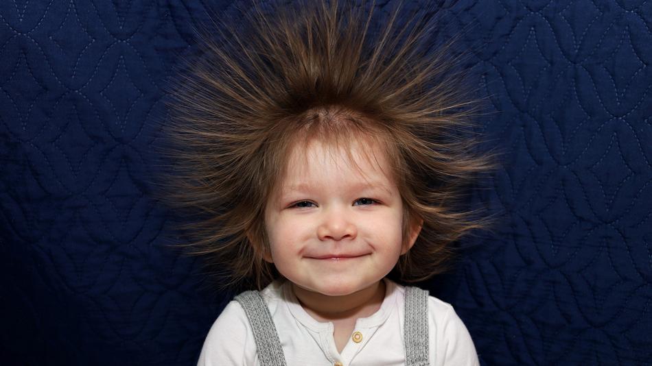 lächelndes Kind mit elektrisierten Haaren