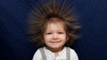 lächelndes Kind mit elektrisierten Haaren