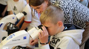Kind schaut in Mikroskop