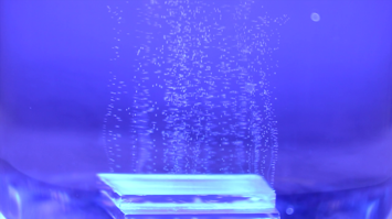 Hintergrund blau, Rechteck aus Glas, darüber feine Partikel