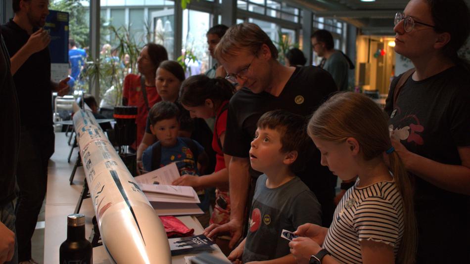 Besucher:innen betrachten die ASTG-Rakete