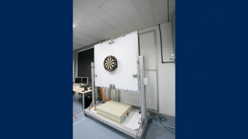 Dartroboter: Labor, weiße Wand, darauf montiert eine Dartscheibe