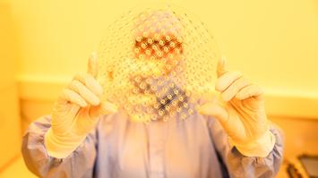 Mitarbeiter:in hält ein nanostrukturiertes Objekt hoch.