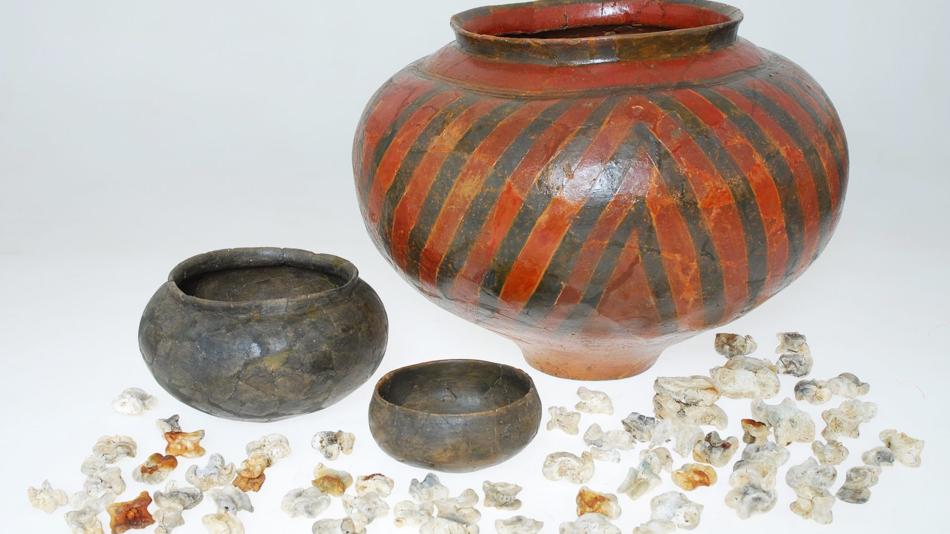 Materielle Kultur des Abschieds: Keramikgefäße enthielten oft Speisen und Getränke für die letzte Reise. Knochen (Astragale) sind Überreste von Fleischbeigaben oder dienten als Spielsteine.