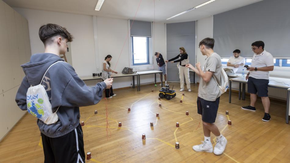 Roboter-Wettrennen: Im Team versucht ihr, den Roboter mithilfe eines Tennisballs schnellstmöglich durch einen Parkour zu steuern.