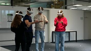 vier junge Menschen mit VR-Brillen