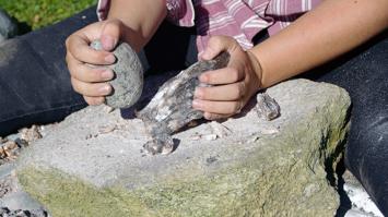 Hände umfassen Stein und archäologisches Objekt