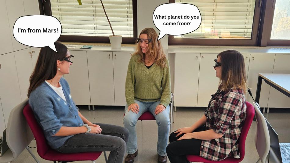 Drei Personen im Gespräch auf Stühlen sitzend mit Eye-Tracking-Brillen