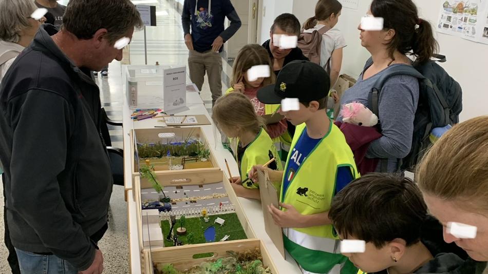 Kinder stehen vor mit verschiedenen Materialien befüllten Kisten