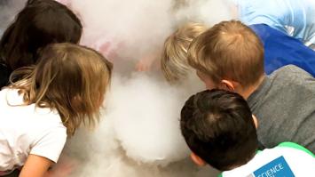 Kinder vor einer rauchenden Schale mit Trockeneis