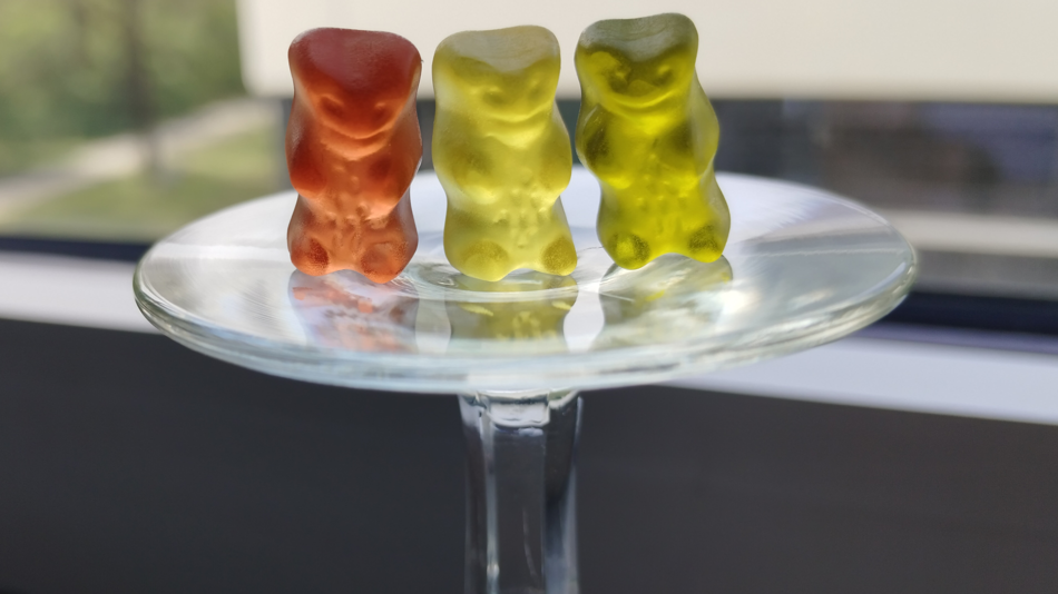 Drei Gummibärchen auf einem umgedrehten Weinglas