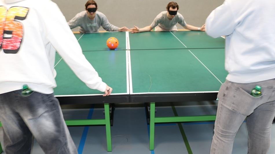 Schüler spielen mit verbundenen Augen mit dem digitalen Klingelball