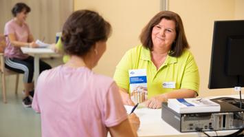 Es sitzen sich zwei Frauen an einem Schreibtisch für das Entlassungsgespräch gegenüber.