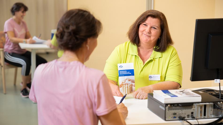 Es sitzen sich zwei Frauen an einem Schreibtisch für das Entlassungsgespräch gegenüber.