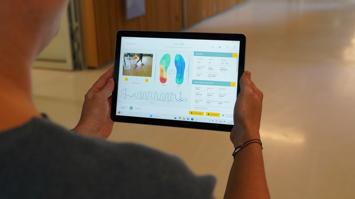 Auf einem Tablet sieht man die Anlayse der intelligenten Einlegesohlen.