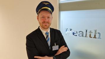 Ein Mann steht als Captain verkleidet bei einem Schriftzug "Health".