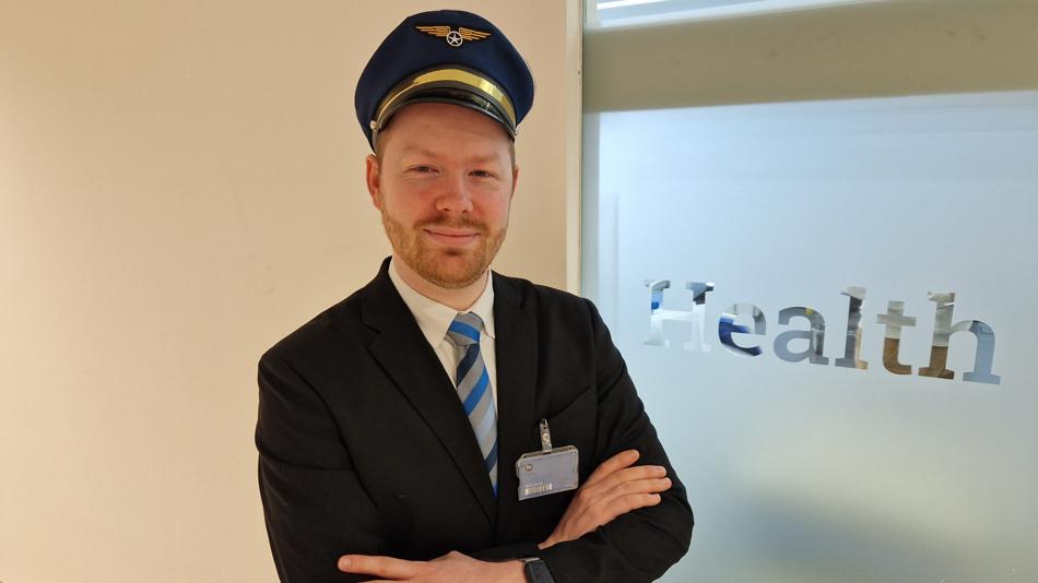 Ein Mann steht als Captain verkleidet bei einem Schriftzug "Health".