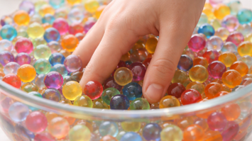 Hand in einer Schüssel mit Hydrogelkugeln
