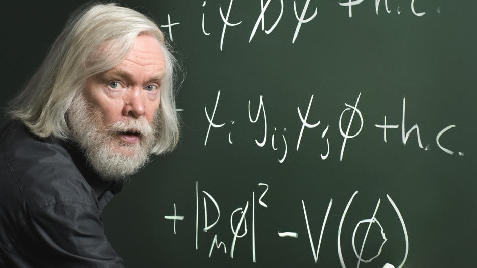 Physiker Peter Higgs vor einem Tafelbild
