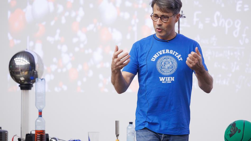 Professor Christoph Dellago bei der Familienvorlesung; im Hintergrund Vorführexperimente