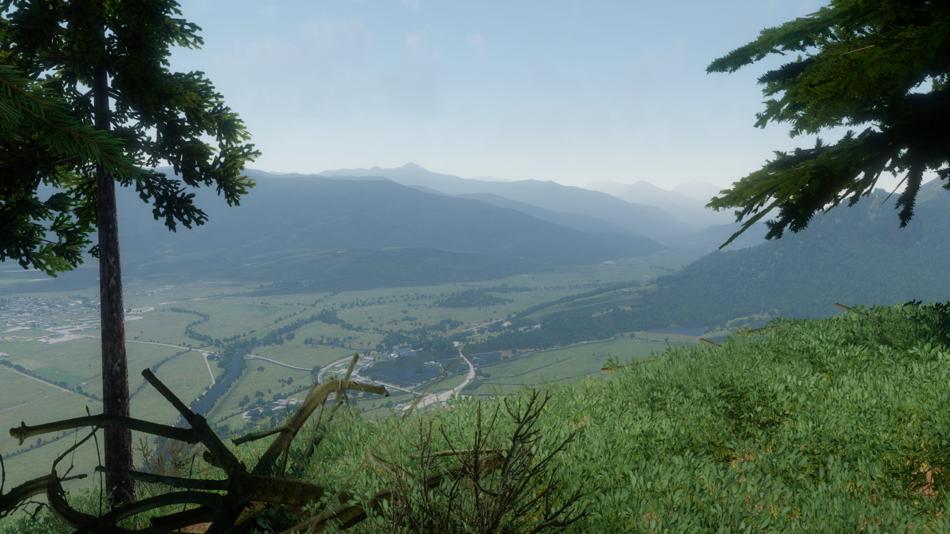 Blick über ein weites Tal mit Bergen und Fluss