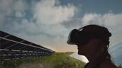 Person mit VR-Brille vor einer Solaranlage im Freien
