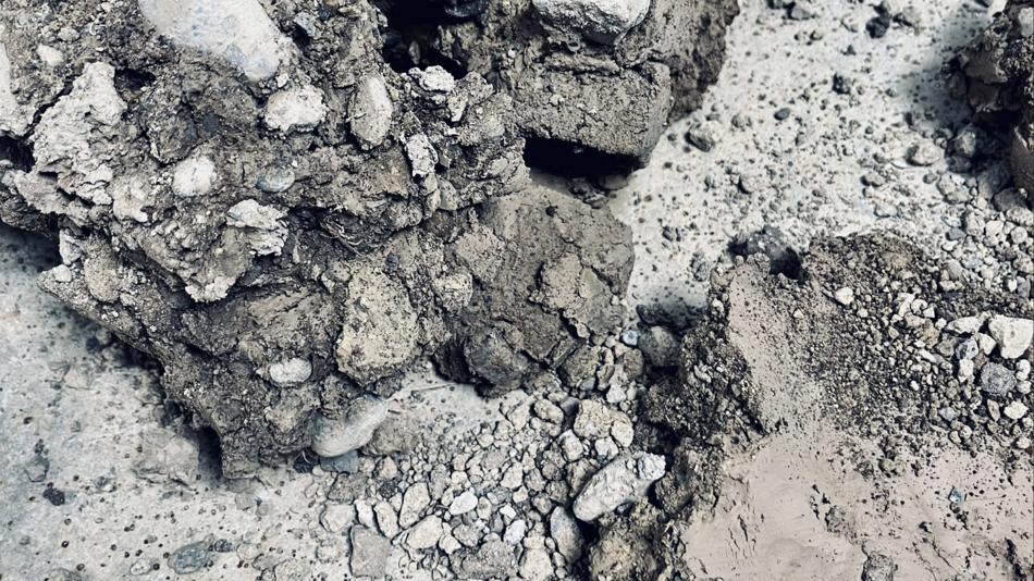 Nahaufnahme von bröseligem, grauem Baustoffmaterial