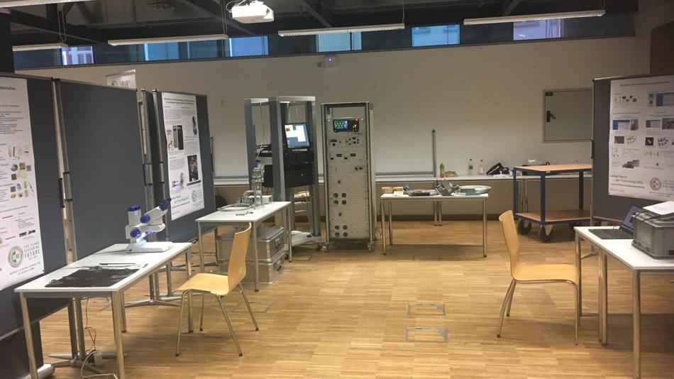 Ein Labor- und Ausstellungsraum mit Messgeräten, Monitoren und wissenschaftlichen Postern