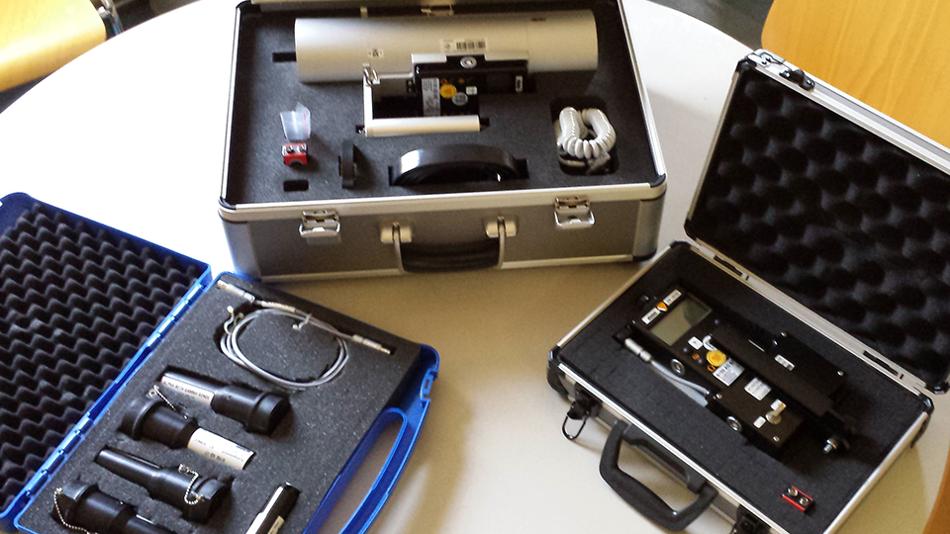 Geöffnete Koffer mit verschiedenen technischen Messgeräten auf einem Tisch