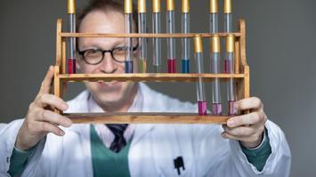 Reagänzgläser in Halterung, im Hintergrund ein Mann