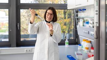 Wissenschaftlerin im Labor mit Probenglas