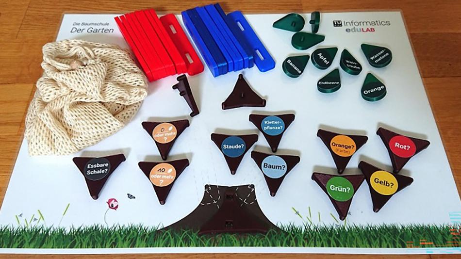 Tisch mit verschiedenen Spielsteinen, die auf einer Matte liegen, auf der ein Baum aufgezeichnet ist