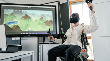 Person mit VR-Brille auf Paraglide-Flugsimulator