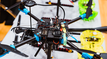 Nahaufnahme einer geöffneten Drohne mit sichtbaren Elektronikbauteilen und Kabeln