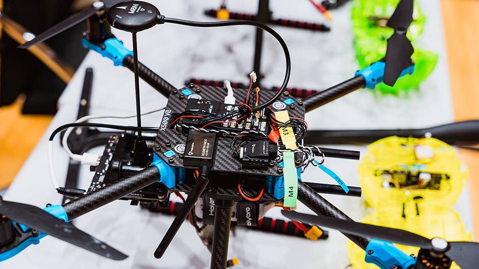 Nahaufnahme einer geöffneten Drohne mit sichtbaren Elektronikbauteilen und Kabeln