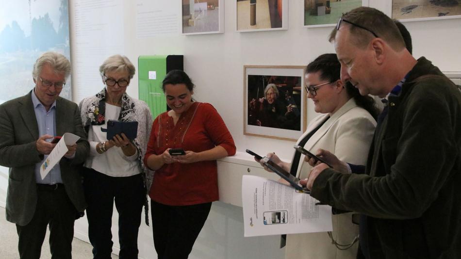 Menschen beim Erkunden des interaktiven Lernpfads zu Alice Harnoncourt.