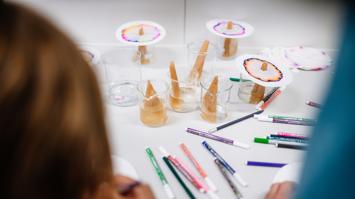 Filzstifte und Papierfilter, auf denen die Farben sich aufspalten, sind zu sehen.