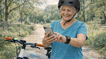 Frau, Fahrrad, Handy, Pulsuhr