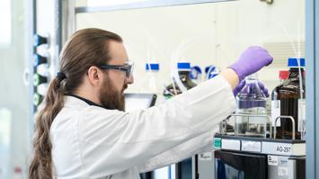 Forschung in Aktion: Ein Wissenschaftler untersucht im Labor sorgfältig chemische Proben, um Herstellprozesse für pharmazeutische Wirkstoffe weiterzuentwickeln und deren Qualität und Sicherheit zu gewährleisten.