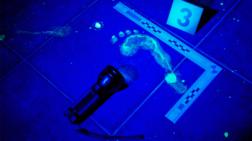 Fußabdruck und Taschenlampe in Schwarzlicht