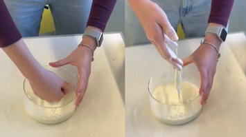 Hand rührt weiße Oobleck‑Mischung in einer Schüssel aus Glas