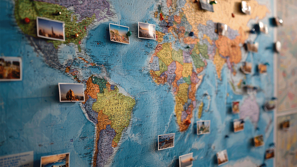Weltkarte auf der Fotos von Sehenswürdigkeiten angepinnt wurden